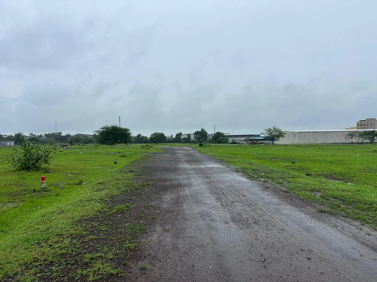 Murum internal road inside the Jaulke layout with industrial buildings visible nearby