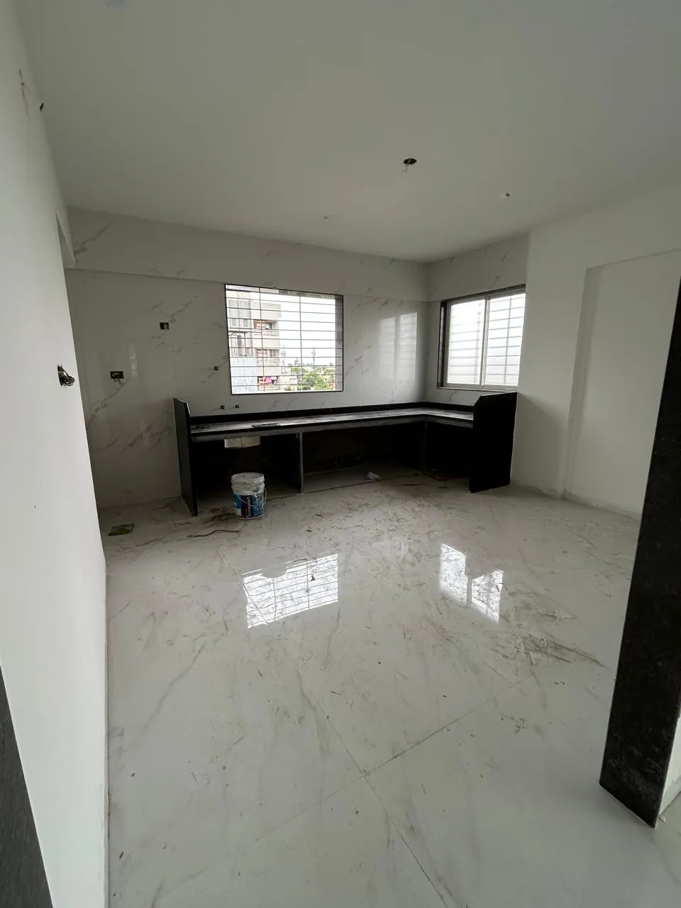 Kitchen-dining area with granite platform and large windows at Prabhupushpa Residency